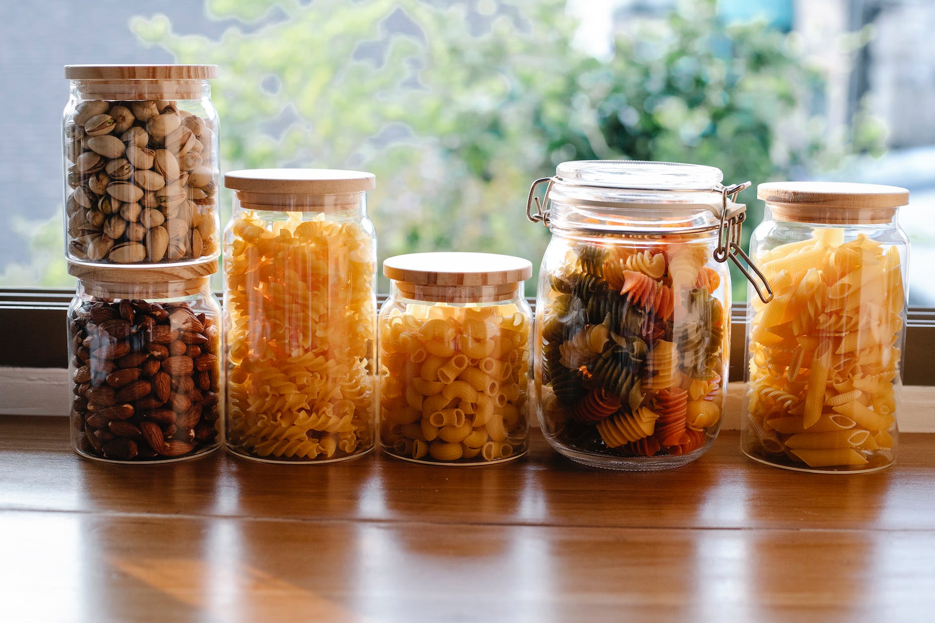 jars with various raw pasta and nuts